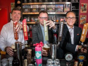 Agriculture Minister Oneil Carlier, ASBA ED Terry Rock and Finance Minister Joe Ceci pull a couple pints. (Photo courtesy of Calgary Herald)